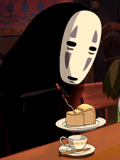 The character No-Face from "Spirited Away" eating a slice of cake