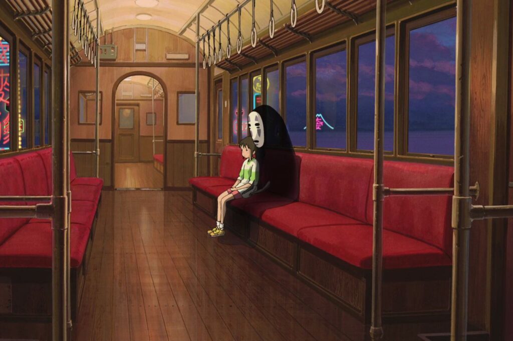 The characters Chihiro and No-Face sitting on an empty train at night